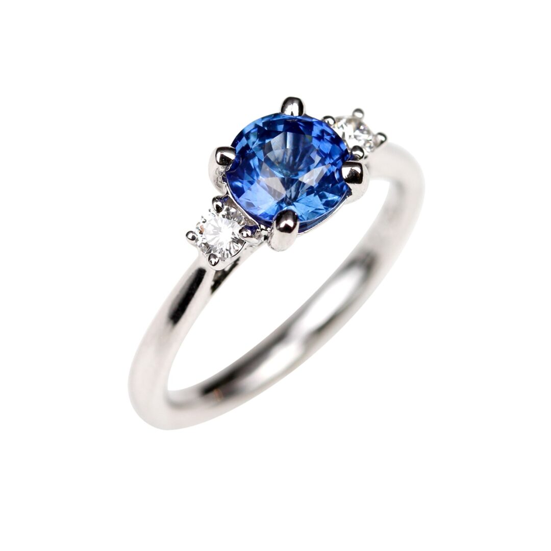 Bague saphir bleu accompagné de deux diamants ronds sur anneau en or blanc