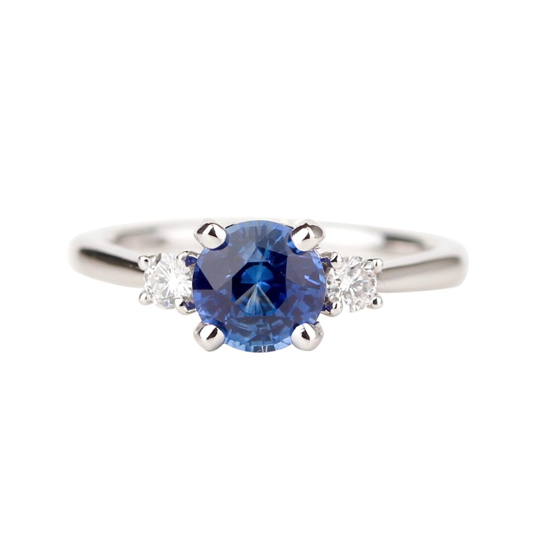 Bague saphir bleu accompagné de deux diamants ronds sur anneau en or blanc