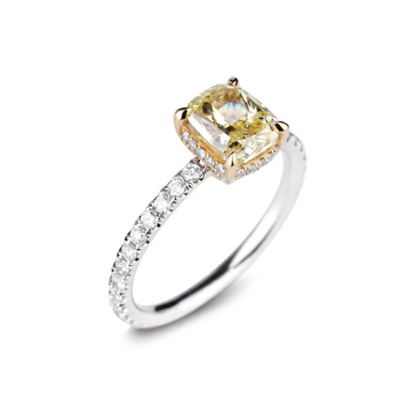 Bague en or bicolore sertie d’un diamant jaune taille coussin de 1,51 carat avec pavage de diamants blancs.