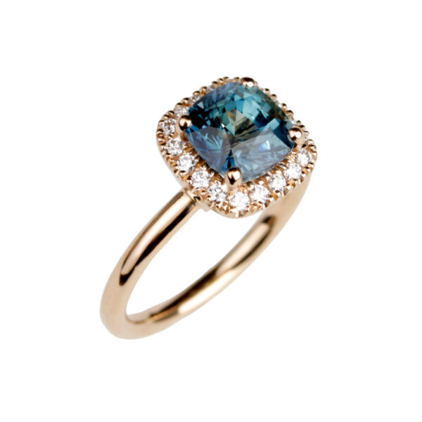 Bague Antoinette en or rose 18 carats sertie d’un saphir teal taille coussin entouré de diamants